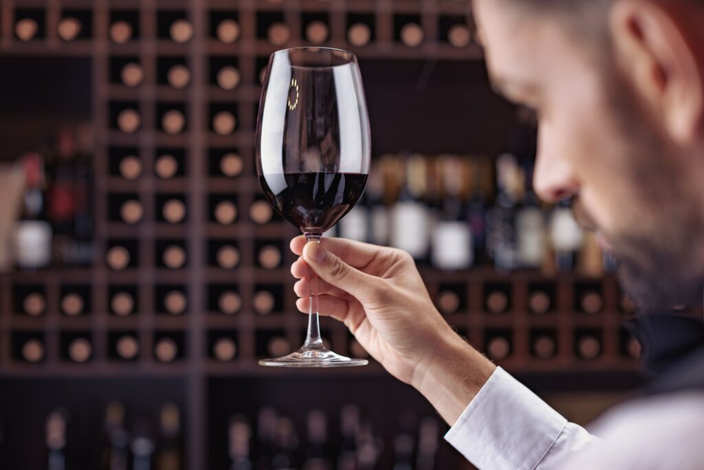 Young handsome man sommelier tasting red wine in cellar